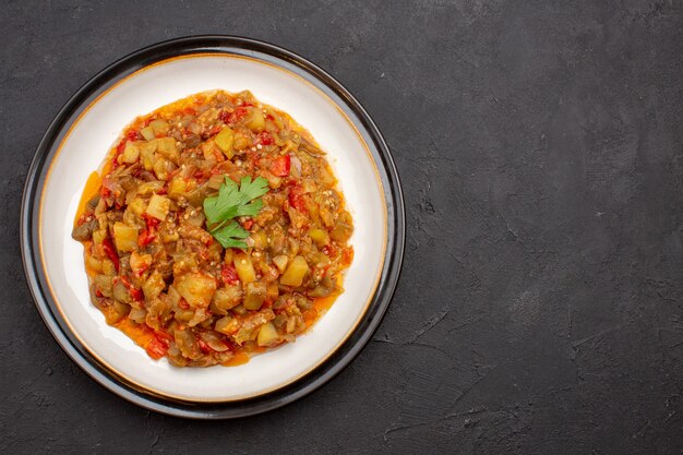 Vista superior deliciosa comida vegetal en rodajas plato cocido dentro de la placa sobre el fondo gris cena comida comida salsa sopa