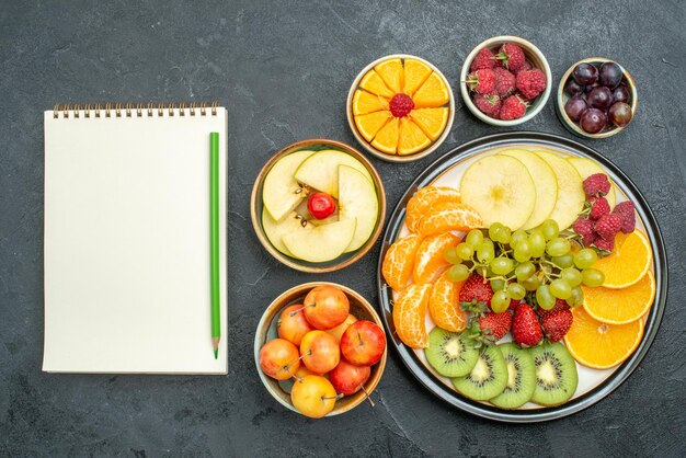 Vista superior de la deliciosa composición de frutas frutas frescas y en rodajas sobre el fondo oscuro fruta fresca madura salud suave