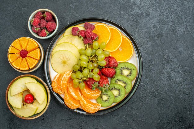 Vista superior de la deliciosa composición de frutas frutas frescas en rodajas y suaves sobre fondo oscuro dieta saludable fresca fruta suave