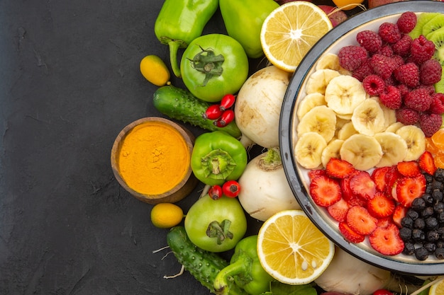 Vista superior deliciosa ensalada de frutas dentro del plato con frutas frescas en el árbol de frutas tropicales gris dieta madura exótica