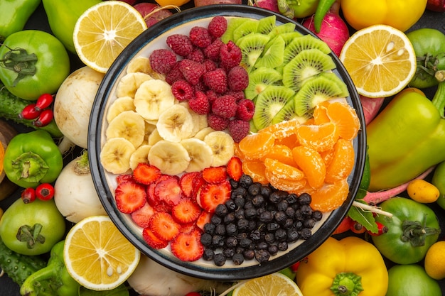 Vista superior deliciosa ensalada de frutas dentro del plato con frutas frescas en el árbol de frutas tropicales gris dieta madura exótica