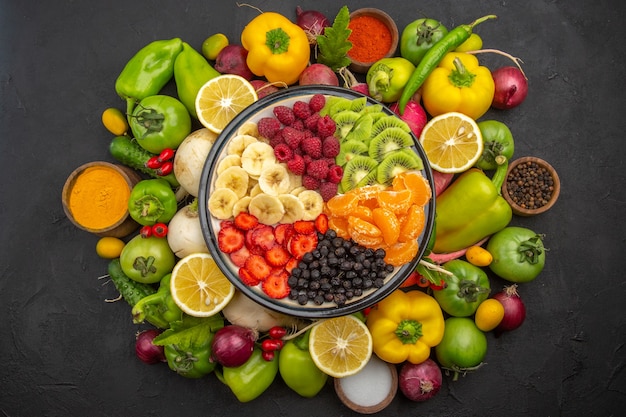 Vista superior deliciosa ensalada de frutas dentro del plato con frutas frescas en un árbol de frutas tropicales oscuro dieta madura exótica