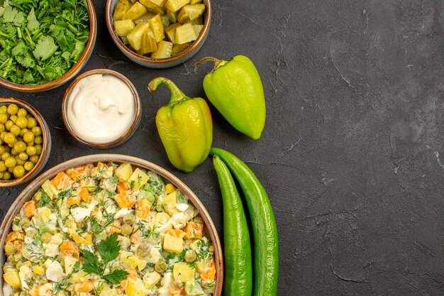 Vista superior de deliciosa ensalada con ingredientes en superficie oscura