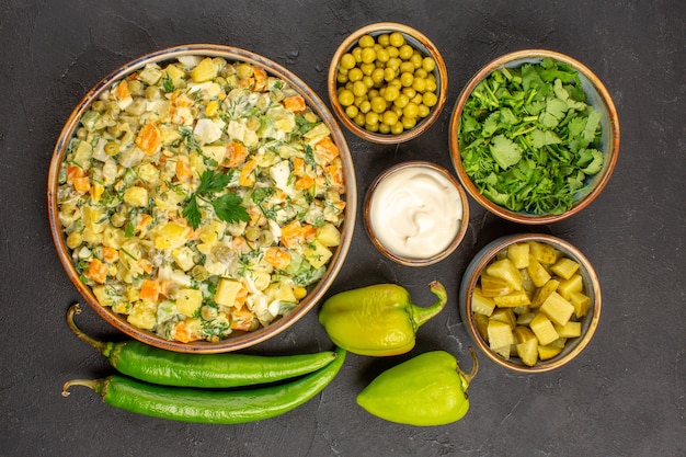 Vista superior de deliciosa ensalada con ingredientes en superficie oscura