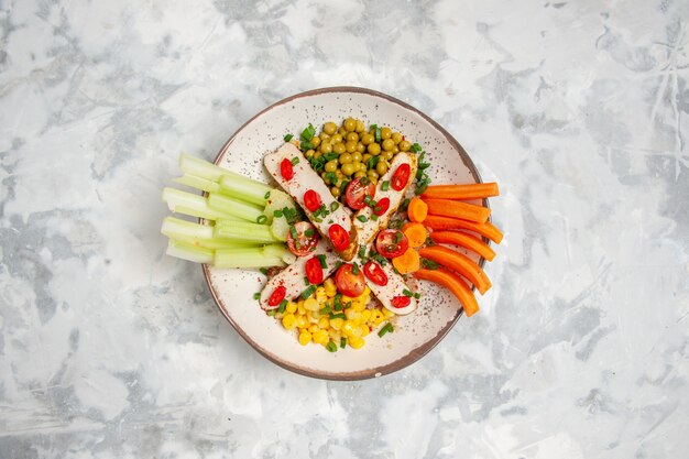 Vista superior de una deliciosa ensalada en un plato sobre la superficie blanca manchada