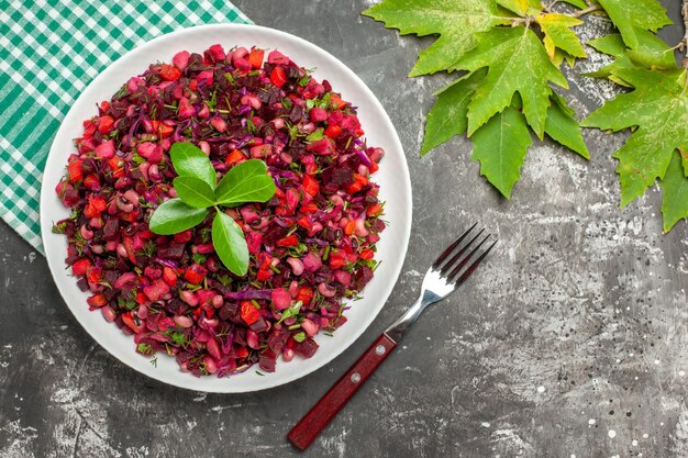 Vista superior deliciosa ensalada de remolacha vinagreta dentro de la placa sobre superficie oscura