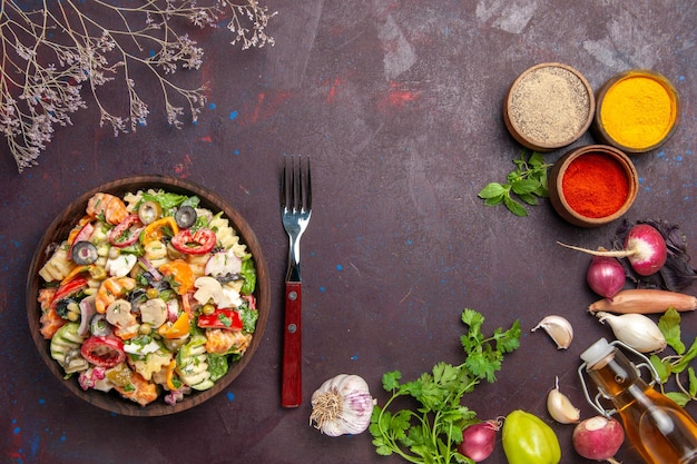 Vista superior deliciosa ensalada de verduras con diferentes condimentos sobre fondo oscuro ensalada de almuerzo de dieta vegetal de salud