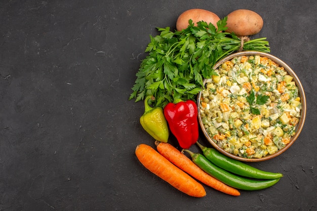 Vista superior de deliciosa ensalada con verduras frescas en superficie oscura