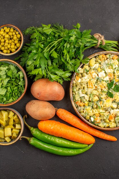 Vista superior de deliciosa ensalada con verduras frescas en superficie oscura