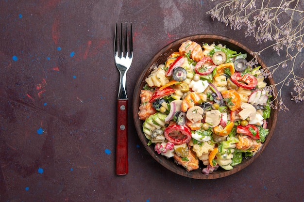 Vista superior deliciosa ensalada de verduras con tomates, aceitunas y champiñones sobre fondo oscuro, dieta saludable, ensalada, verduras, almuerzo, merienda