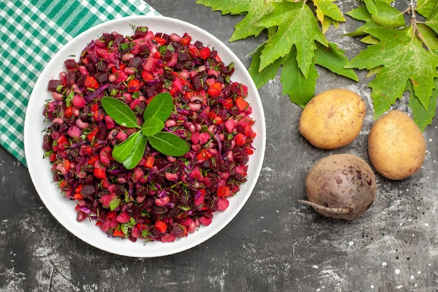 Vista superior deliciosa ensalada de vinagreta de remolacha dentro de la placa en superficie gris