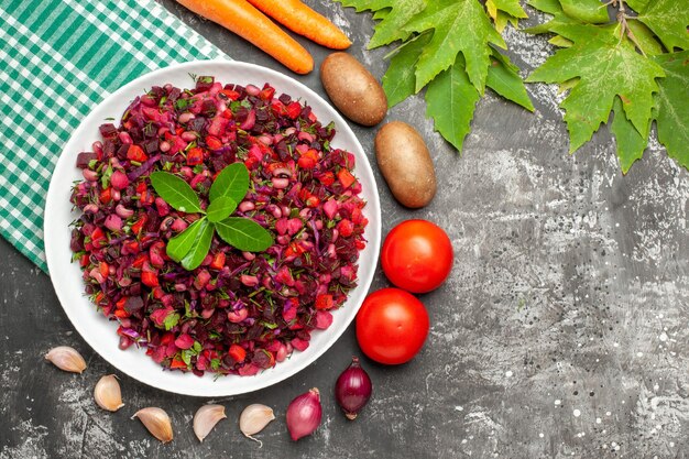 Vista superior deliciosa ensalada de vinagreta de remolacha con verduras en la superficie gris