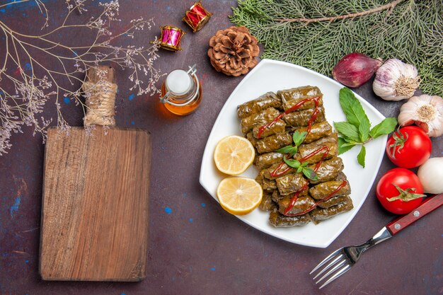 Vista superior de la deliciosa hoja dolma con rodajas de limón en el fondo oscuro plato de carne hoja cena comida comida