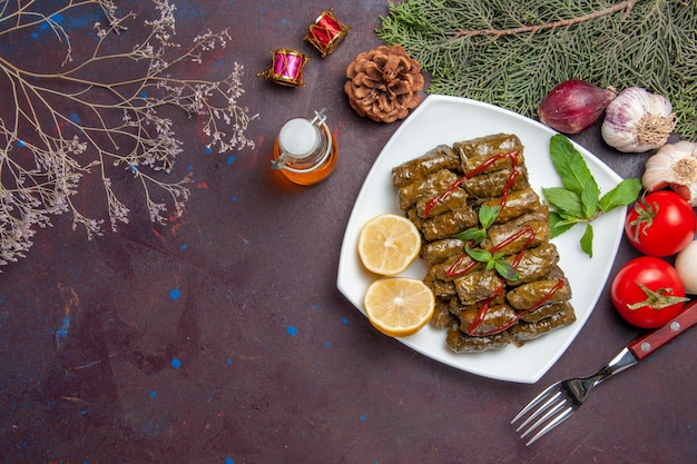 Vista superior de la deliciosa hoja dolma con rodajas de limón en el fondo oscuro plato de carne hoja cena comida comida