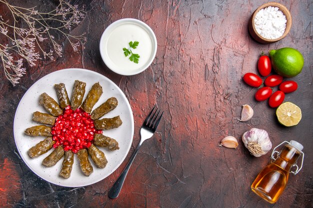 Vista superior de la deliciosa hoja dolma con tomates en superficie oscura