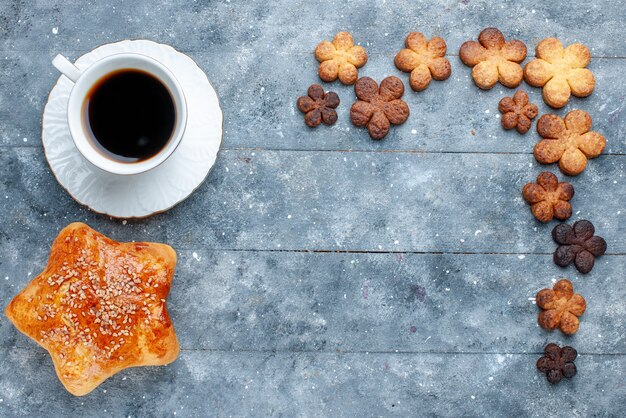 Vista superior de la deliciosa pastelería dulce en forma de estrella con café de galletas en gris, pastel de pastelería dulce