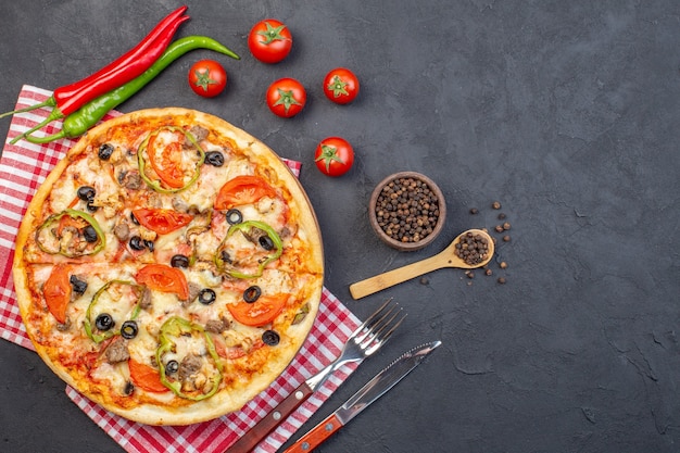 Vista superior deliciosa pizza de queso con aceitunas pimiento y tomates en superficie oscura