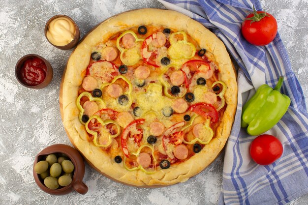 Vista superior deliciosa pizza con queso con aceitunas, salchichas y tomates en el fondo brillante comida de comida de masa italiana de comida rápida