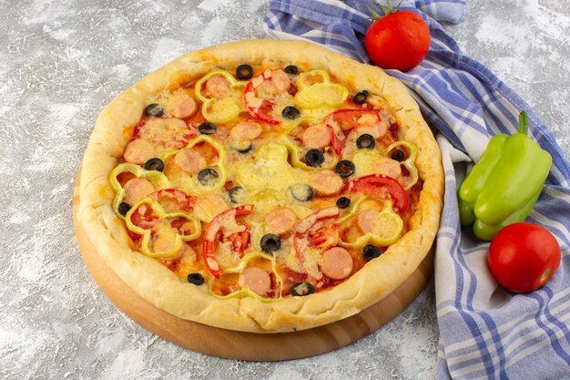 Vista superior deliciosa pizza con queso con aceitunas, salchichas y tomates en la mesa de luz comida rápida comida de masa italiana