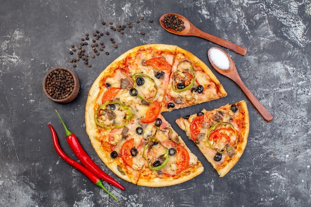 Vista superior de la deliciosa pizza de queso en rodajas y servida en una superficie gris
