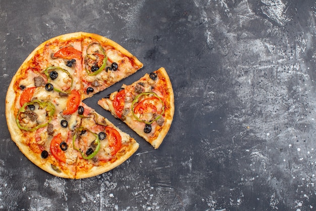 Vista superior de la deliciosa pizza de queso en rodajas y servida en una superficie gris