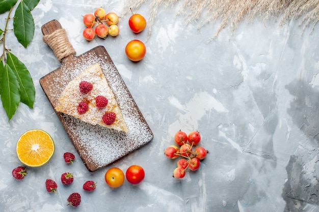 Vista superior deliciosa rebanada de pastel delicioso con frutas en la galleta de pastel de azúcar de escritorio blanco