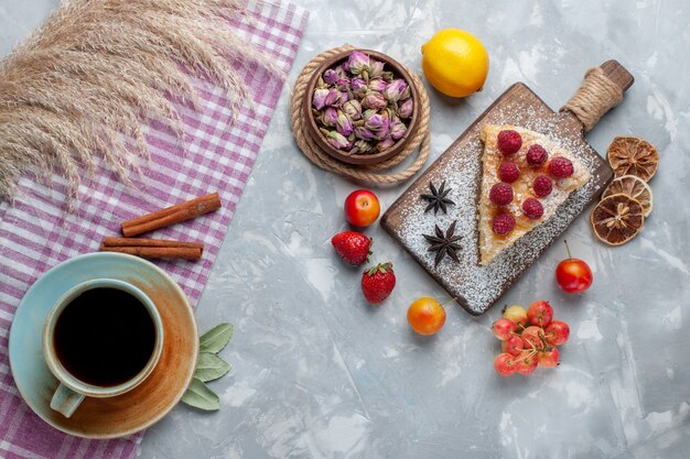 Vista superior deliciosa rebanada de pastel con té de limón y frutas en la mesa de luz pastel galleta dulce azúcar hornear