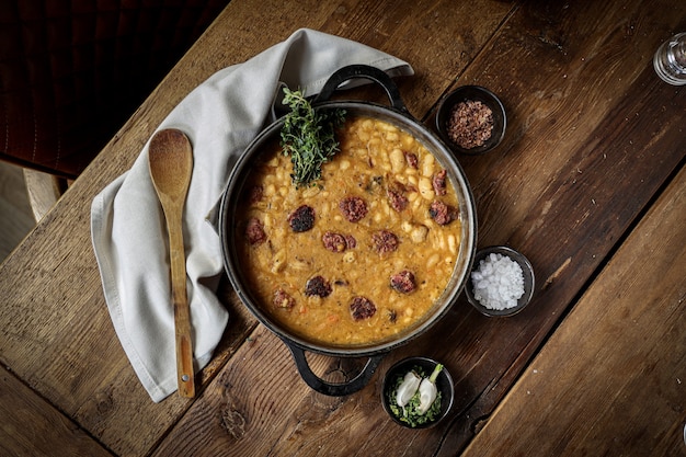 Vista superior de la deliciosa salchicha de ternera casera con frijoles servida en una mesa de madera