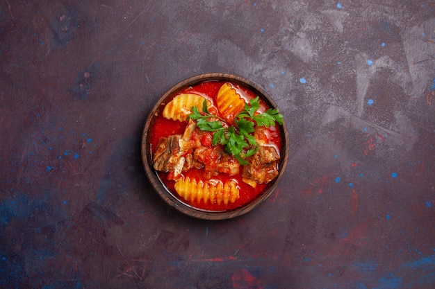 Vista superior deliciosa salsa de carne con verduras y papas en rodajas en el plato de cena de comida de sopa de salsa de superficie oscura