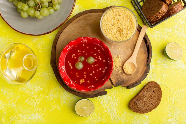 Vista superior deliciosa salsa de tomate con pan en la mesa amarilla sopa comida comida vegetal