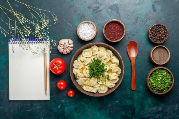 Vista superior deliciosa sopa de bola de masa con diferentes condimentos en el escritorio verde sopa de masa de carne comida vegetal