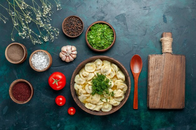 Vista superior deliciosa sopa de bola de masa con diferentes condimentos en la superficie verde sopa de alimentos masa de carne vegetal