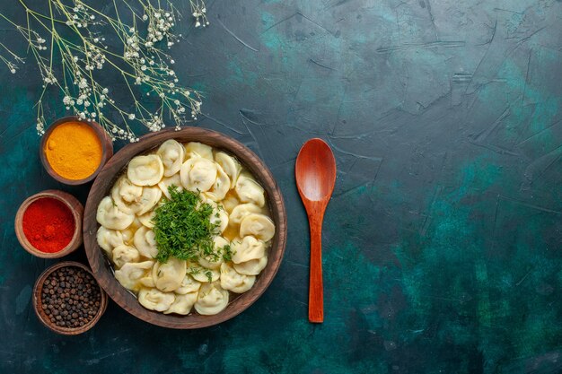 Vista superior deliciosa sopa de bola de masa con verduras y diferentes condimentos en el escritorio oscuro, masa de sopa, comida vegetal