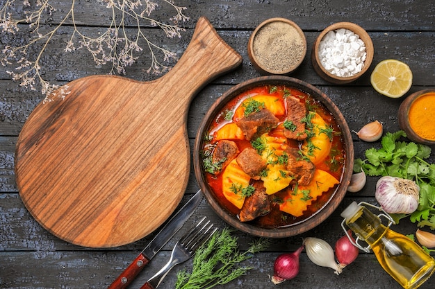 Vista superior deliciosa sopa de carne con patatas y verduras en el escritorio oscuro