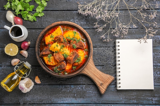 Vista superior deliciosa sopa de carne con patatas y verduras en el escritorio oscuro