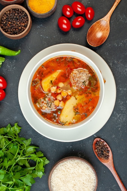 Vista superior deliciosa sopa de carne con verduras y condimentos sobre fondo oscuro