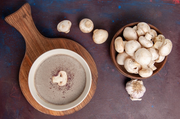 Vista superior deliciosa sopa de champiñones con champiñones en el escritorio oscuro