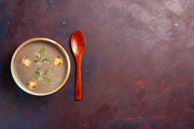 Vista superior deliciosa sopa de champiñones dentro de la placa en el escritorio oscuro