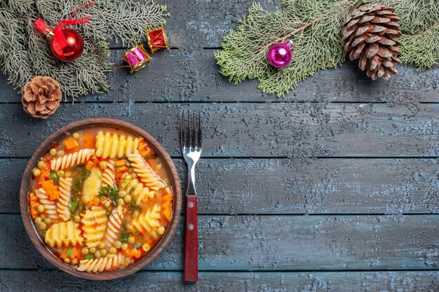 Vista superior de la deliciosa sopa de pasta de pasta italiana en espiral con verduras en el escritorio azul oscuro, cocina, sopa de pasta, plato de color, cena