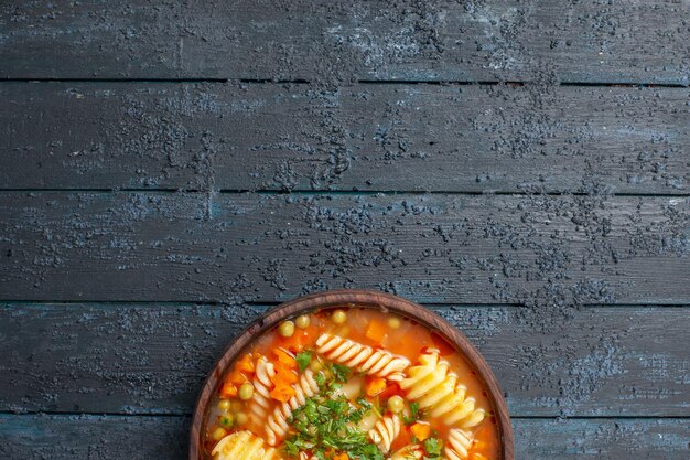 Vista superior deliciosa sopa de pasta con verduras y verduras dentro de la placa en el escritorio oscuro plato salsa de cena de sopa de pasta italiana