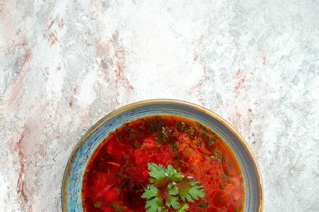 Vista superior deliciosa sopa de remolacha ucraniana borsch famosa con carne dentro de la placa en el escritorio blanco