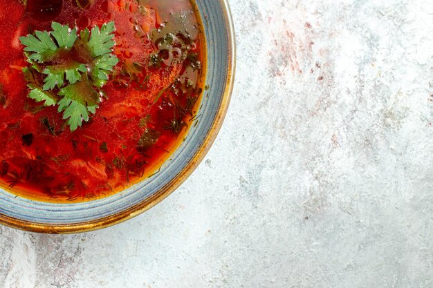 Vista superior deliciosa sopa de remolacha ucraniana borsch famosa con carne dentro de la placa en un espacio en blanco claro