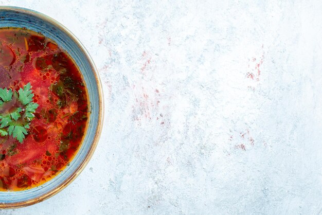 Vista superior deliciosa sopa de remolacha ucraniana borsch famosa con carne dentro de la placa en el espacio en blanco