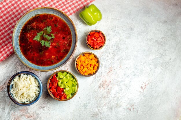 Vista superior deliciosa sopa de remolacha ucraniana borsch famosa con carne y pimienta en un espacio en blanco claro