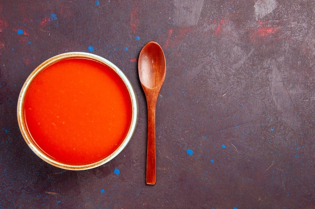 Vista superior deliciosa sopa de tomate cocinada con tomates frescos en el fondo oscuro plato salsa comida sopa de tomate