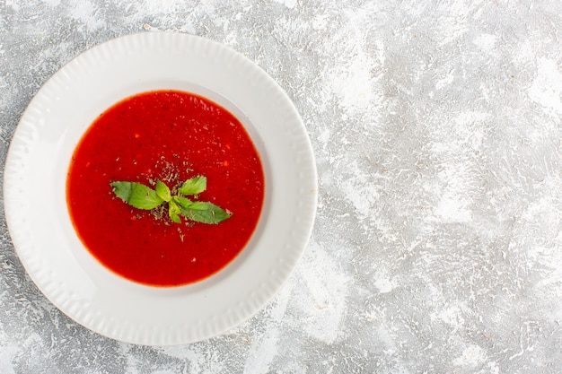 Foto gratuita vista superior deliciosa sopa de tomate con condimentos en mesa gris, cena de sopa