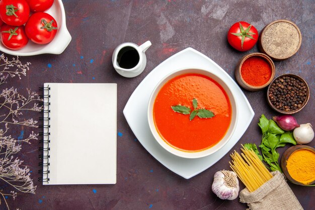 Vista superior deliciosa sopa de tomate con tomates frescos y condimentos en el fondo oscuro plato comida salsa tomate color sopa