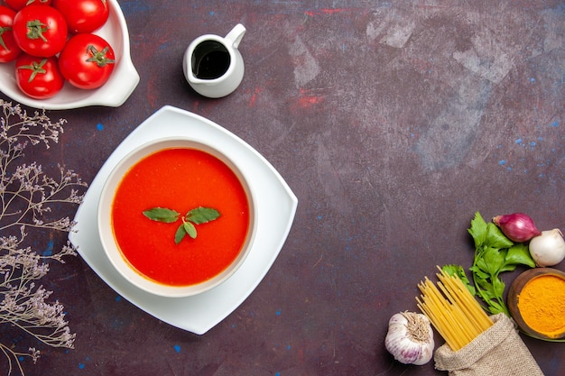 Vista superior deliciosa sopa de tomate con tomates frescos en un plato de escritorio oscuro salsa sopa de comida de color tomate