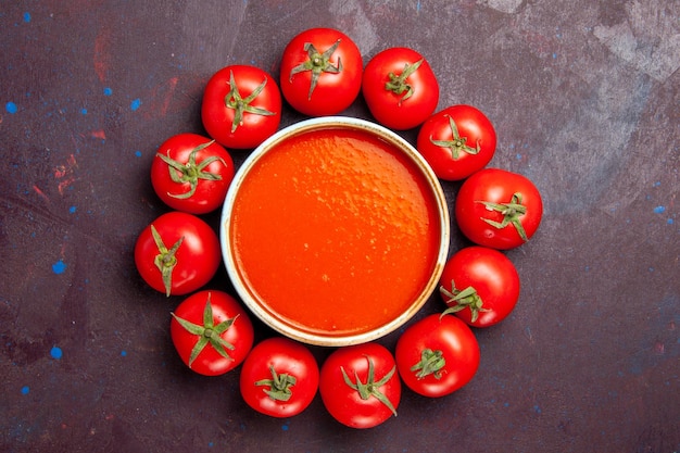 Vista superior deliciosa sopa de tomate con tomates frescos sobre fondo oscuro plato de tomates cena sopa salsa comida