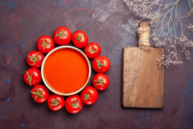 Vista superior deliciosa sopa de tomate con tomates rojos frescos en el plato de cena de comida de sopa de tomate de fondo oscuro